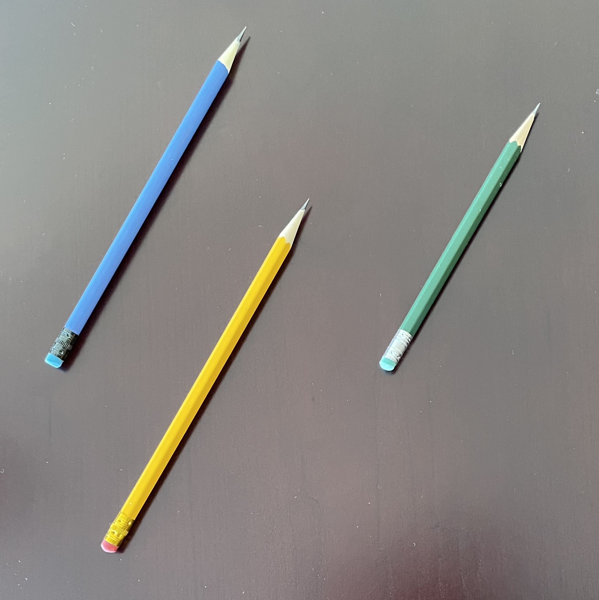 Three pencils, but just two vectors. The yellow and blue pencils have the same length and direction, so they are exactly the same vector. Pencils have position, but vectors don't. The green pencil shares the same direction, but it has a different length, so it is a different vector from the blue/yellow vector.